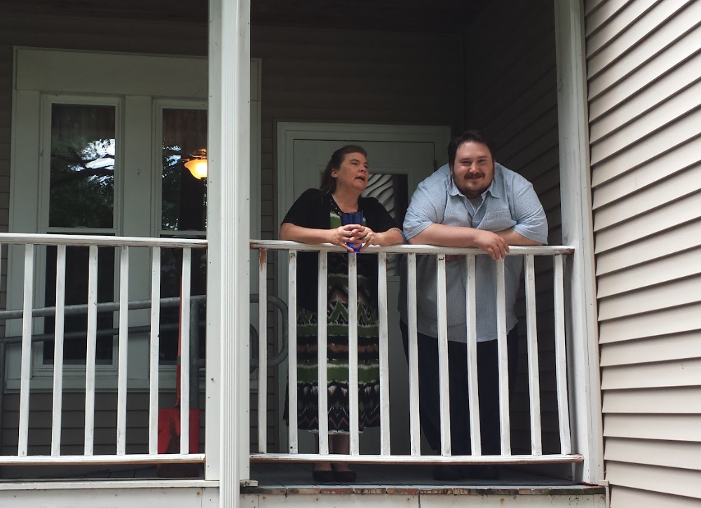 VOA Northern New England behavioral health services: man and woman smiling while standing and leaning on balcony railing